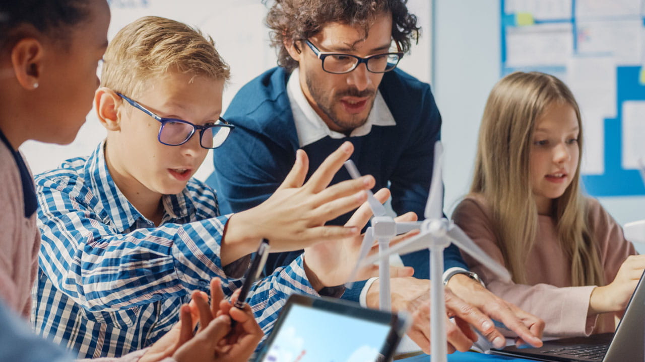 High school students engaging with Lumio interactive lessons on tablets in a collaborative classroom environment.