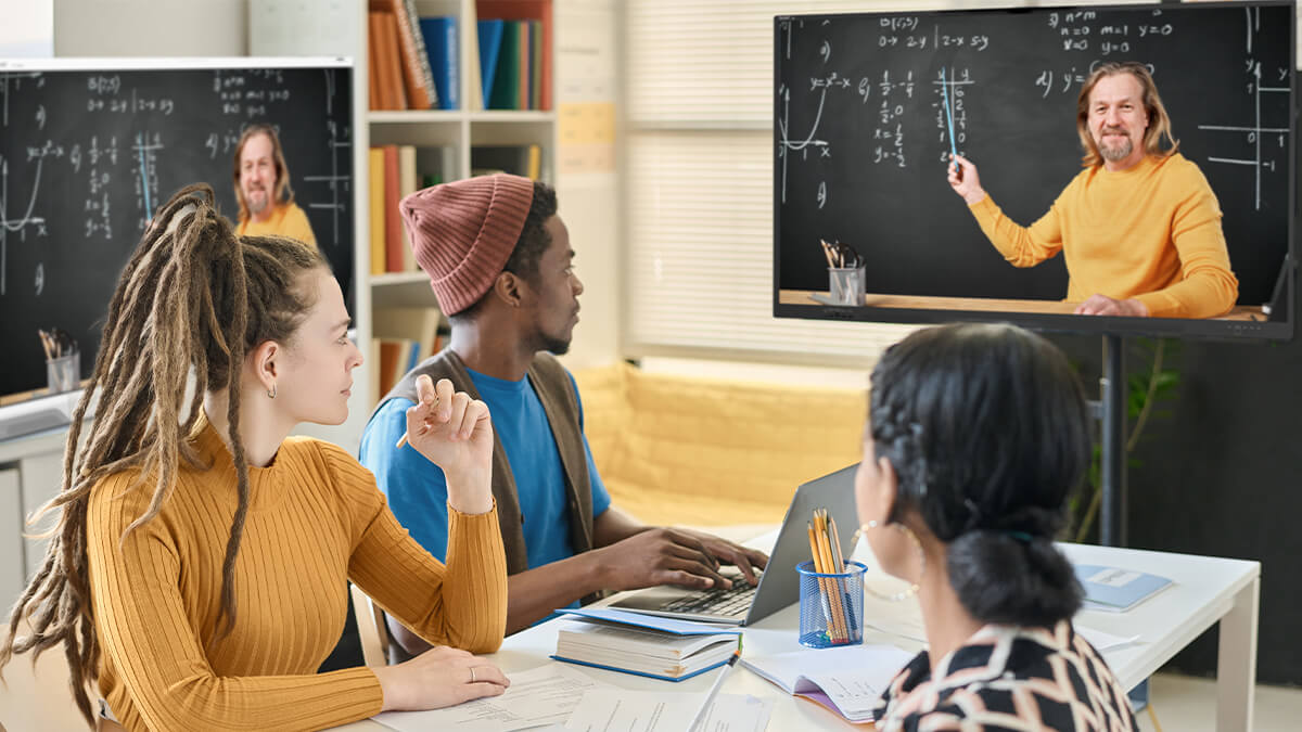 Students in a classroom engaged in a lesson with a teacher on a SMART Board NX series non-interactive display.