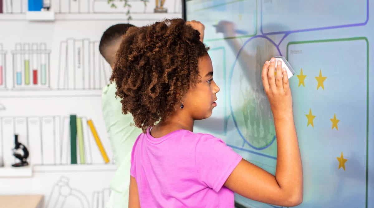 Young student using a Tool Explorer stamp on a SMART Board 6000S series in the classroom, illustrating interactive learning.